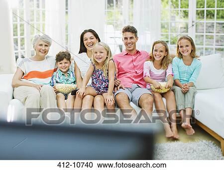 Stock Image - Family watching television together. Fotosearch