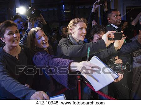 Stock Photography - Fans reaching for autographs at red carpet event. Fotosearch