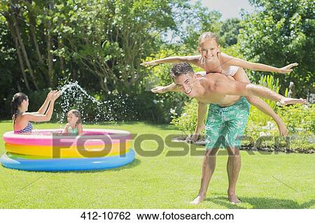 Father and daughter playing in backyard View Large Photo Image Stock Image - Father and daughter playing in backyard. Fotosearch