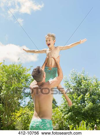 Stock Photograph - Father and son playing in backyard. Fotosearch