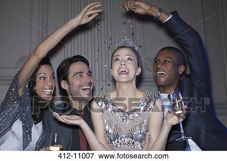 Friends reaching over happy woman wearing tiara View Large Photo Image Stock Photo - Friends reaching over happy woman wearing tiara. Fotosearch
