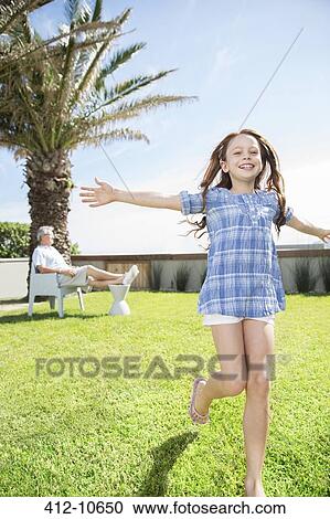 Stock Image - Girl playing in backyard. Fotosearch