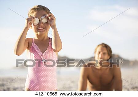 Girl playing with seashells on beach View Large Photo Image Stock Photography - Girl playing with seashells on beach. Fotosearch