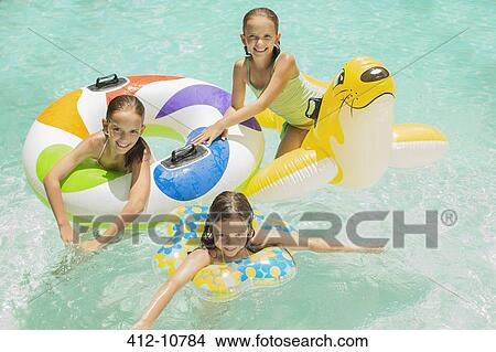 Girls playing together in swimming pool View Large Photo Image Picture - Girls playing together in swimming pool. Fotosearch