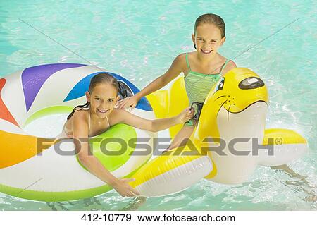 Stock Photo - Girls playing together in swimming pool. Fotosearch