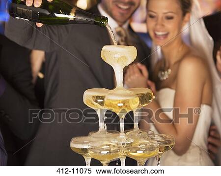 Groom pouring champagne pyramid at wedding reception View Large Photo Image Stock Photography - Groom pouring champagne pyramid at wedding reception. Fotosearch