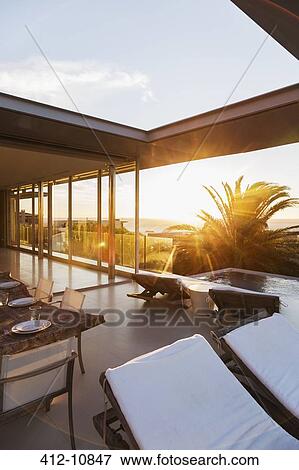 Lawn chairs and set table on modern patio View Large Photo Image Stock Photo - Lawn chairs and set table on modern patio. Fotosearch