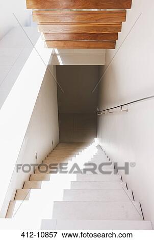Light shining down staircase in modern house View Large Photo Image Stock Photo - Light shining down staircase in modern house. Fotosearch
