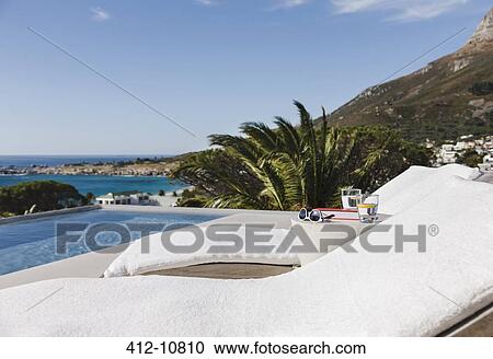 Lounge chairs and pool overlooking ocean View Large Photo Image Stock Image - Lounge chairs and pool overlooking ocean. Fotosearch