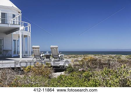 Lounge chairs on deck overlooking ocean View Large Photo Image Picture - Lounge chairs on deck overlooking ocean. Fotosearch