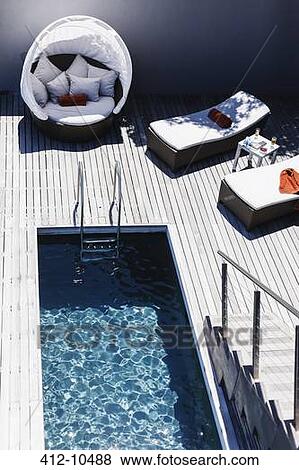 Lounge chairs on wooden deck near lap pool View Large Photo Image Stock Photo - Lounge chairs on wooden deck near lap pool. Fotosearch