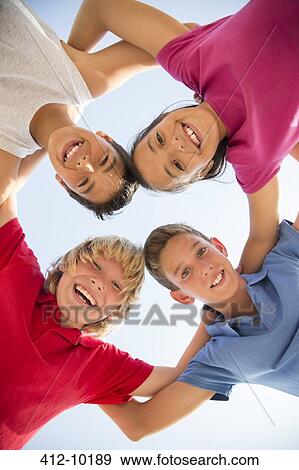 Low angle view of children smiling in huddle View Large Photo Image Stock Photo - Low angle view of children smiling in huddle. Fotosearch