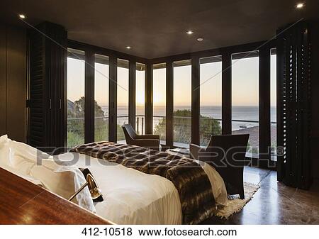 Luxury bedroom overlooking ocean at sunset View Large Photo Image Stock Photo - Luxury bedroom overlooking ocean at sunset. Fotosearch
