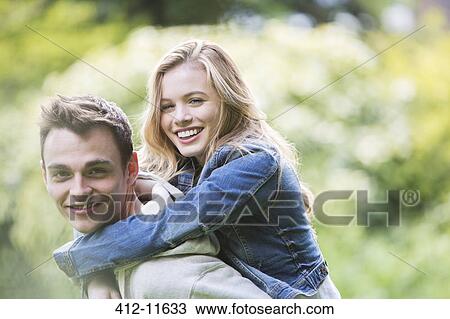 Man carrying girlfriend piggyback outdoors View Large Photo Image Stock Image - Man carrying girlfriend piggyback outdoors. Fotosearch