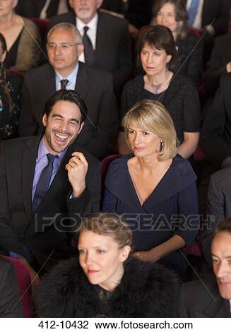 Man laughing among serious theater audience View Large Photo Image Stock Image - Man laughing among serious theater audience. Fotosearch