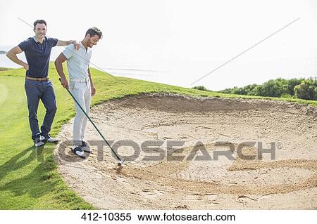 Men raking heart-shape in sand trap on golf course View Large Photo Image Stock Photography - Men raking heart-shape in sand trap on golf course. Fotosearch