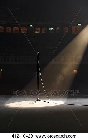 Microphone in spotlight on empty theater stage View Large Photo Image Stock Photo - Microphone in spotlight on empty theater stage. Fotosearch