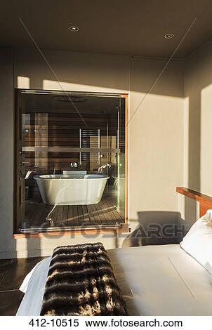 Modern bedroom with glass window to bathroom View Large Photo Image Stock Photography - Modern bedroom with glass window to bathroom. Fotosearch