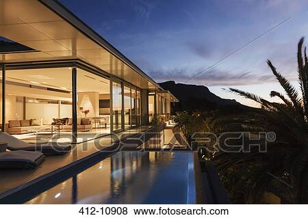 Stock Photo - Modern house overlooking mountains at dusk. Fotosearch