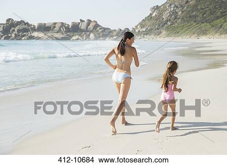 Mother and daughter running on beach View Large Photo Image Picture - Mother and daughter running on beach. Fotosearch