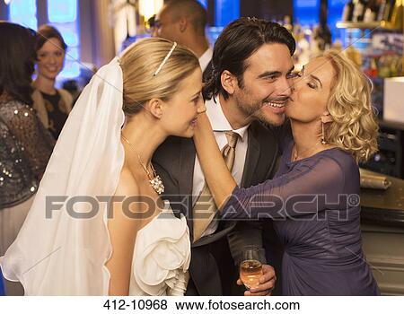Mother kissing groom at wedding reception View Large Photo Image Stock Photo - Mother kissing groom at wedding reception. Fotosearch