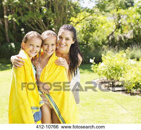 Stock Photograph - Mother wrapping daughters in towel. Fotosearch