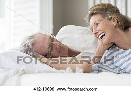 Older couple relaxing on bed View Large Photo Image Stock Photo - Older couple relaxing on bed. Fotosearch