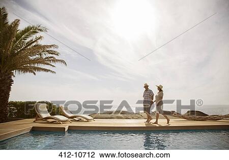 Older couple relaxing together by pool View Large Photo Image Stock Image - Older couple relaxing together by pool. Fotosearch