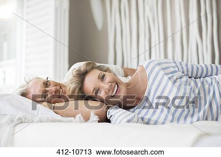 Older couple relaxing together on bed View Large Photo Image Stock Image - Older couple relaxing together on bed. Fotosearch