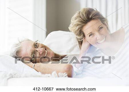 Stock Photo - Older couple smiling on bed. Fotosearch