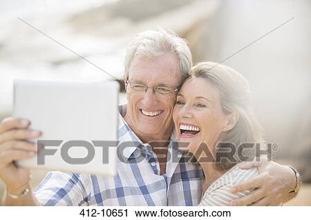 Older couple taking pictures with digital tablet View Large Photo Image Stock Image - Older couple taking pictures with digital tablet. Fotosearch