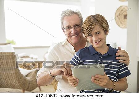 Older man and grandson using digital tablet View Large Photo Image Stock Image - Older man and grandson using digital tablet. Fotosearch