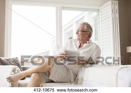 Older man using digital tablet in bedroom View Large Photo Image Stock Photography - Older man using digital tablet in bedroom. Fotosearch