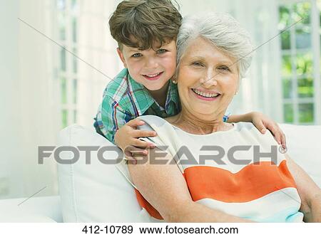 Stock Photo - Older woman and grandson smiling in living room. Fotosearch