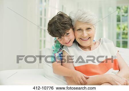 Older woman and grandson smiling in living room View Large Photo Image Stock Photograph - Older woman and grandson smiling in living room. Fotosearch