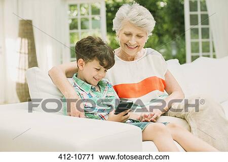 Older woman and grandson using cell phone View Large Photo Image Stock Image - Older woman and grandson using cell phone. Fotosearch