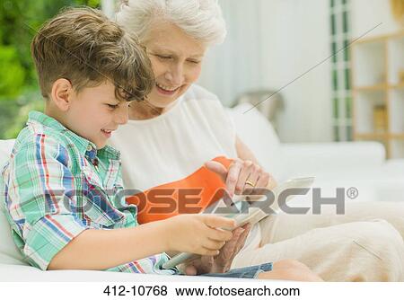 Stock Photo - Older woman and grandson using digital tablet. Fotosearch