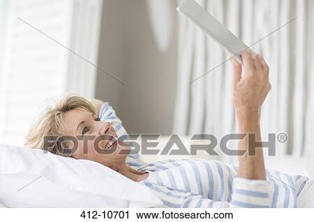 Stock Image - Older woman using digital tablet. Fotosearch