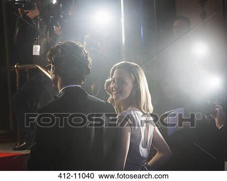Stock Image - Paparazzi photographing celebrity couple at red carpet event. Fotosearch