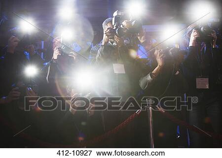 Stock Photo - Paparazzi using flash photography at red carpet event. Fotosearch