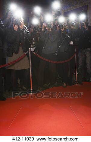 Stock Photo - Paparazzi using flash photography at red carpet event. Fotosearch