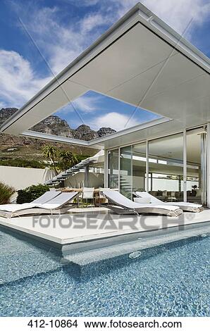 Patio and swimming pool along modern house View Large Photo Image Picture - Patio and swimming pool along modern house. Fotosearch