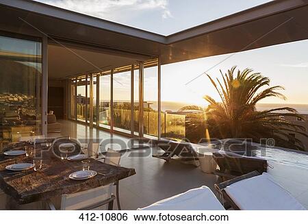 Patio overlooking swimming pool and ocean at sunset View Large Photo Image Stock Photograph - Patio overlooking swimming pool and ocean at sunset. Fotosearch