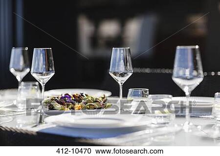 Stock Image - Place settings on elegant dining table. Fotosearch
