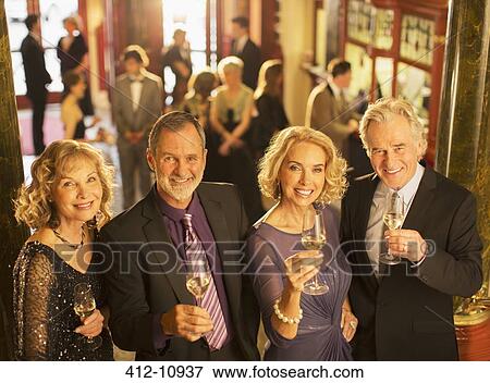 Portrait of happy well dressed couples toasting champagne flutes View Large Photo Image Stock Photo - Portrait of happy well dressed couples toasting champagne flutes. Fotosearch