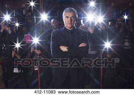 Portrait of serious bodyguard with paparazzi using flash photography in background View Large Photo Image Stock Image - Portrait of serious bodyguard with paparazzi using flash photography in background. Fotosearch