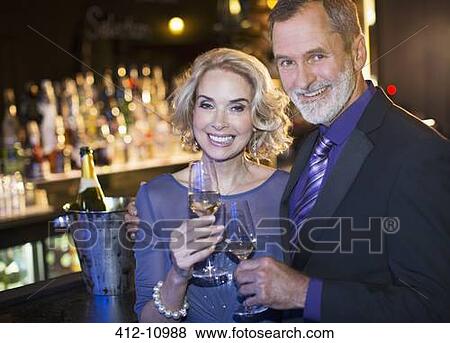 Portrait of well dressed couple drinking champagne in luxury bar View Large Photo Image Stock Photo - Portrait of well dressed couple drinking champagne in luxury bar. Fotosearch