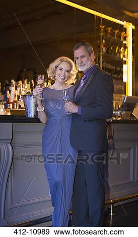 Portrait of well dressed couple drinking champagne in luxury bar View Large Photo Image Stock Photo - Portrait of well dressed couple drinking champagne in luxury bar. Fotosearch