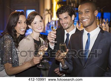 Portrait of well dressed couples toasting champagne flutes View Large Photo Image Stock Image - Portrait of well dressed couples toasting champagne flutes. Fotosearch