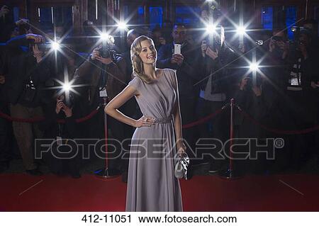 Portrait of well dressed female celebrity on red carpet with paparazzi in background View Large Photo Image Stock Image - Portrait of well dressed female celebrity on red carpet with paparazzi in background. Fotosearch
